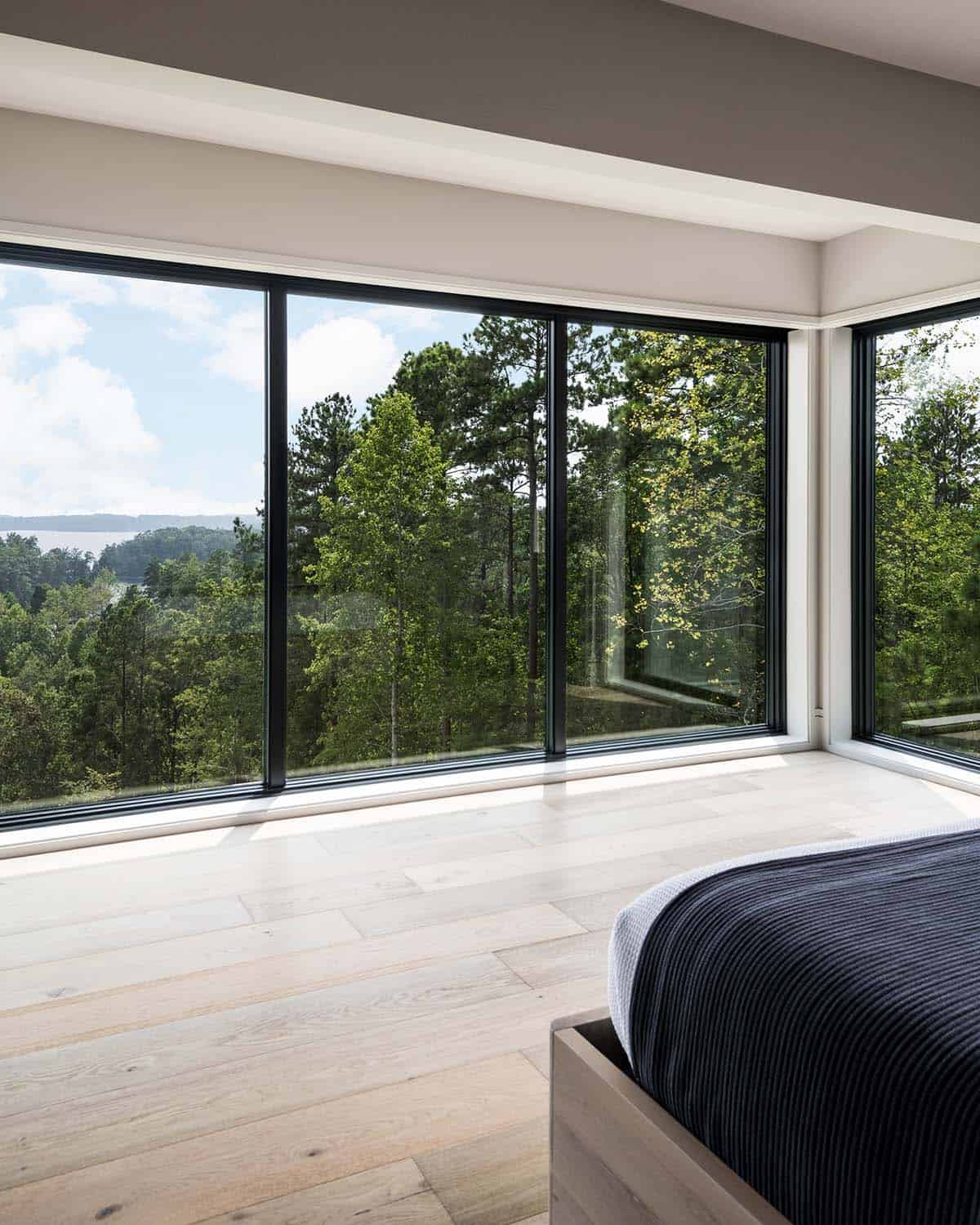 Corner bedroom windows framing lake and forest views from upper floor