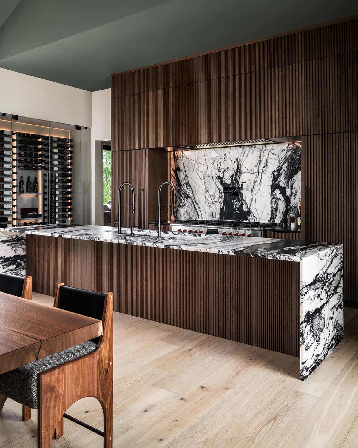 Kitchen island with black-and-white marble waterfall edge and ribbed wood paneling