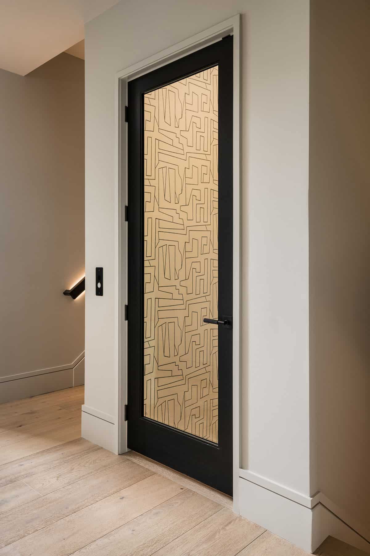 Elevator door with abstract gold geometric pattern and black frame