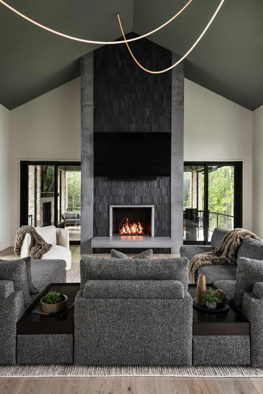 Vaulted living room with black hexagonal tile fireplace and gray sectional sofa