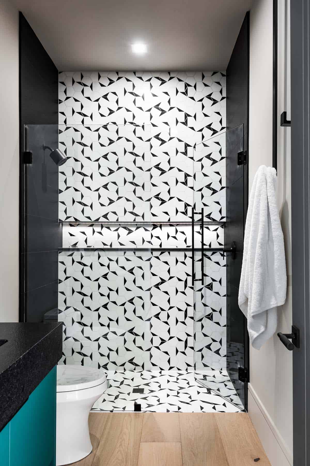 Guest shower with black-and-white geometric hexagon tile and glass enclosure