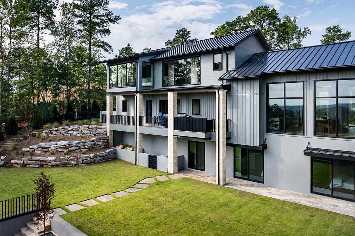 Rear exterior with stacked stone terracing and covered upper balcony