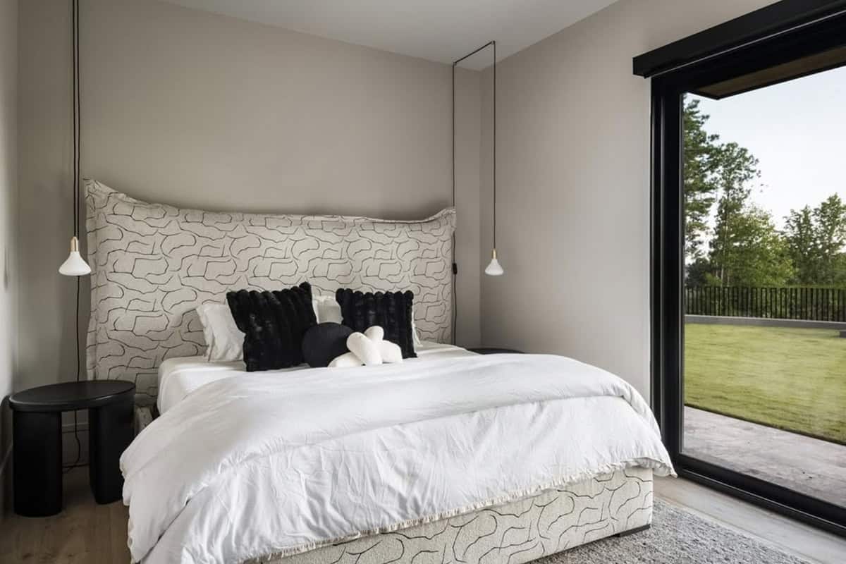 Guest bedroom with abstract patterned headboard and sliding door to backyard