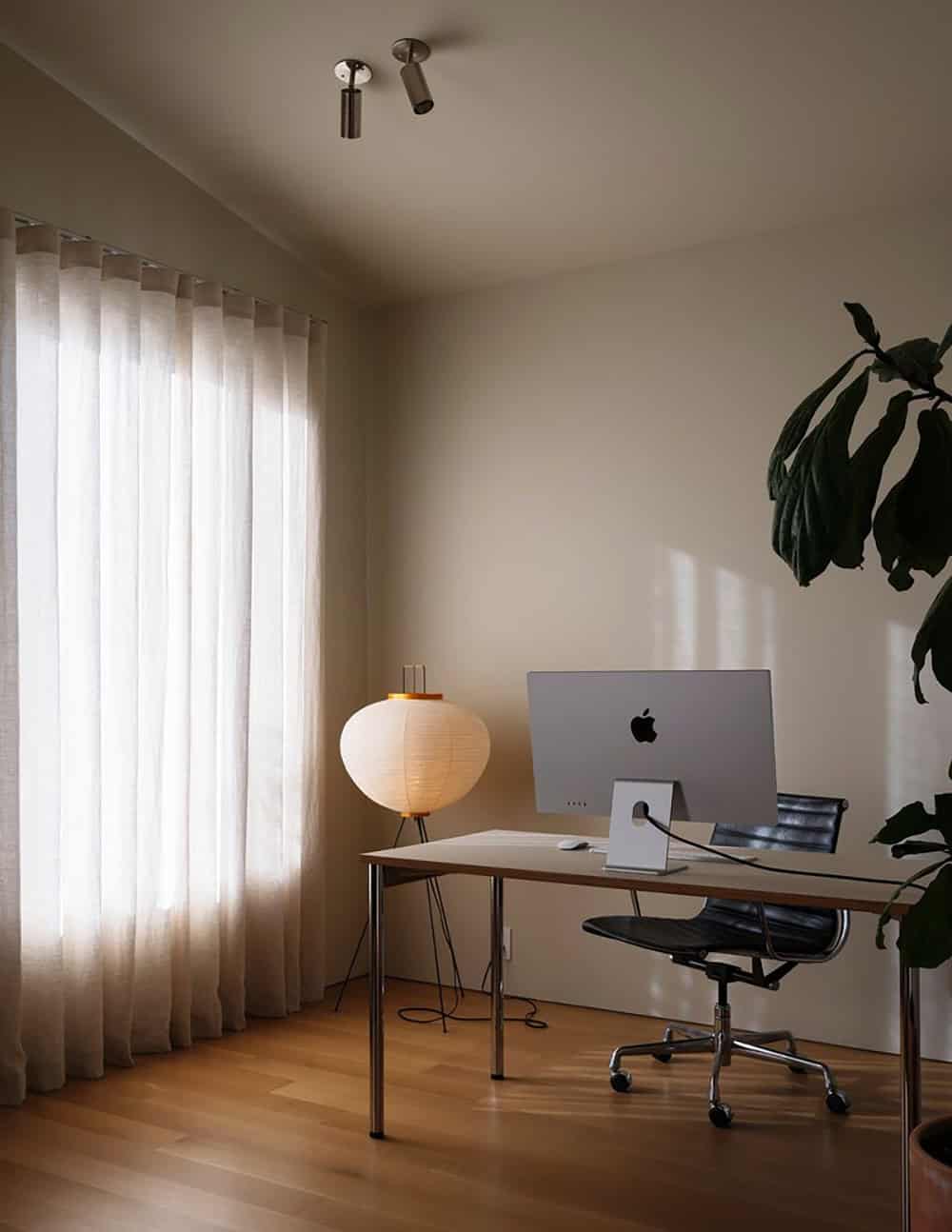 Home office with sheer curtains, paper table lamp, and iMac on a minimal desk