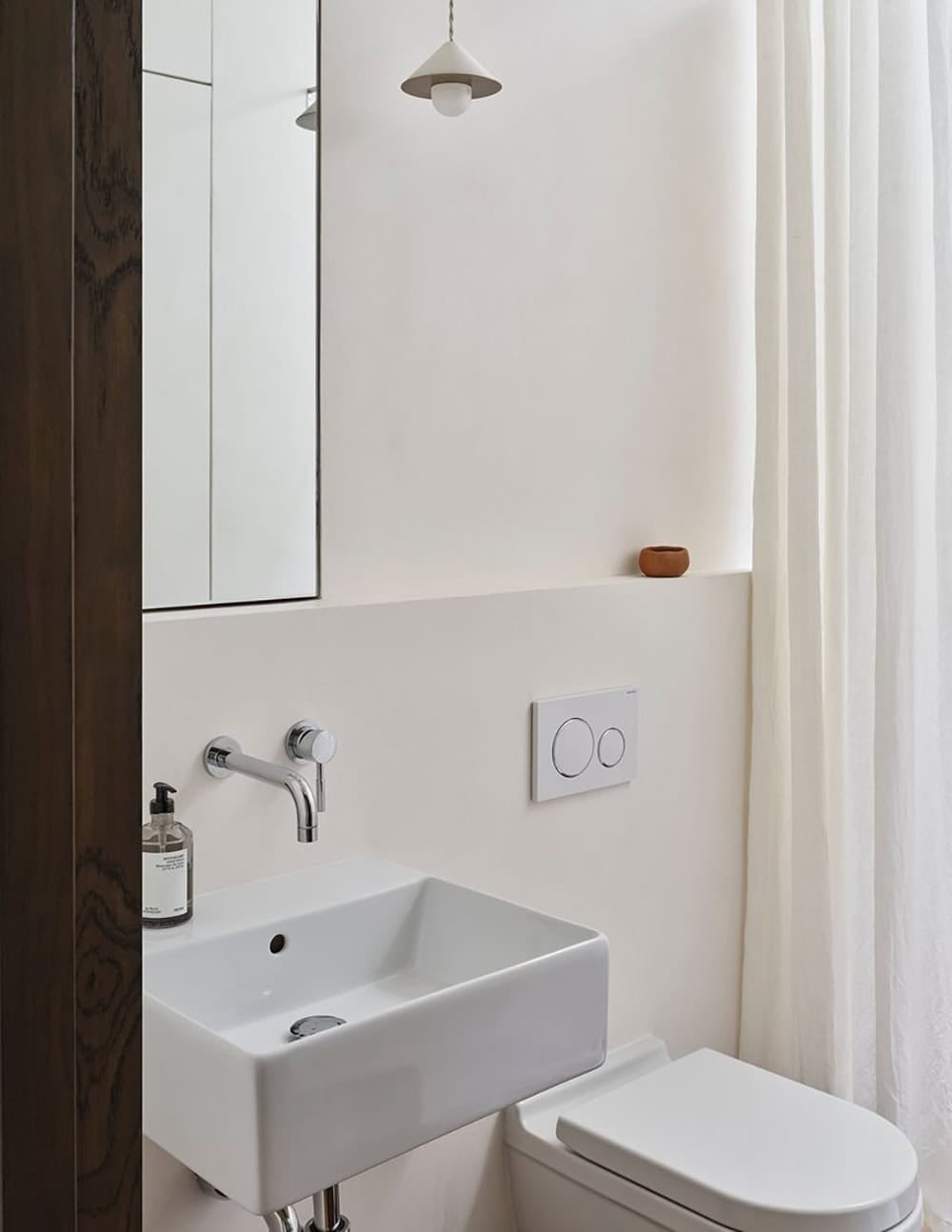 Compact powder room with wall-mount sink, mirror cabinet, and ceramic pendant light