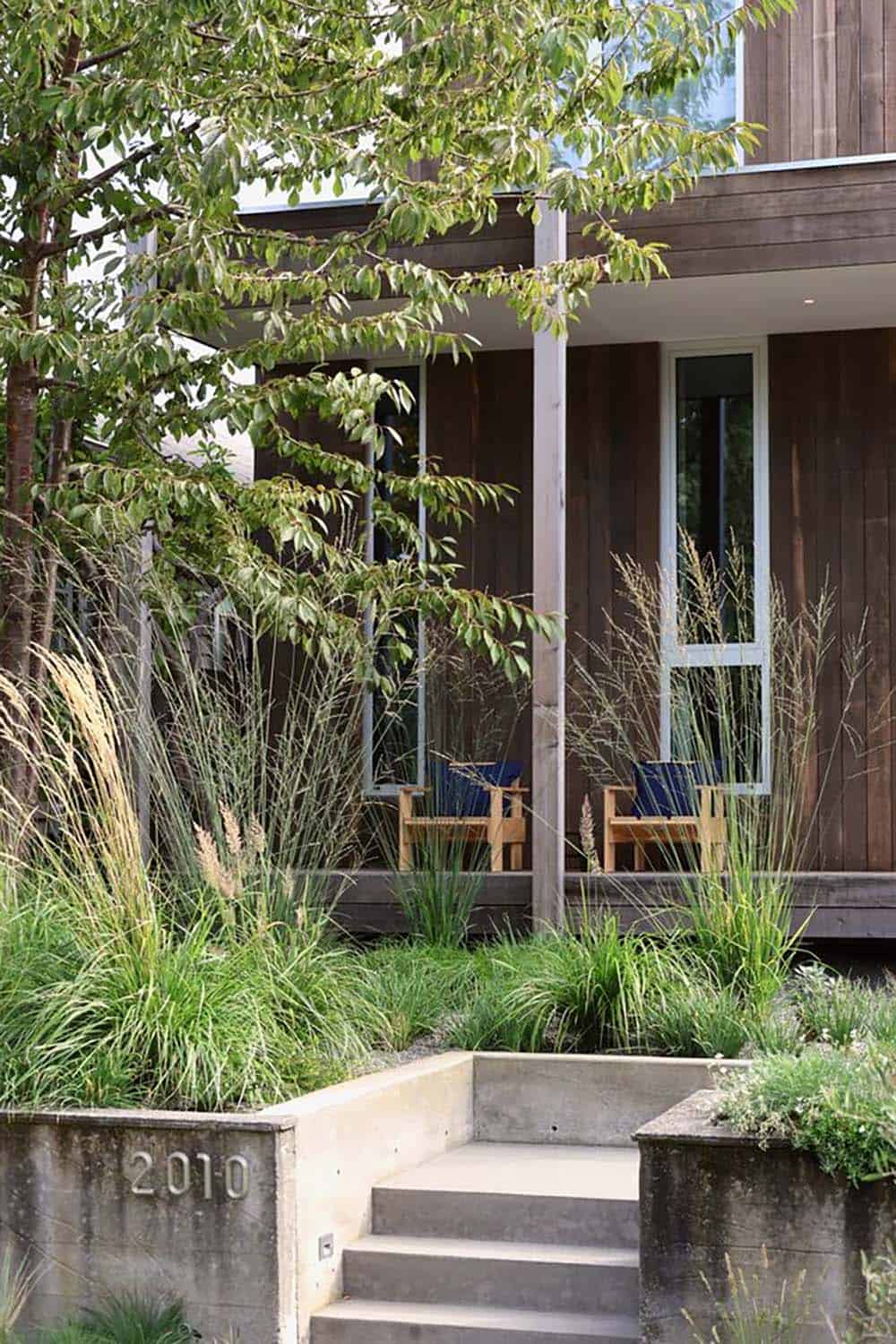 Front entry path through native garden plantings with cedar siding and covered porch