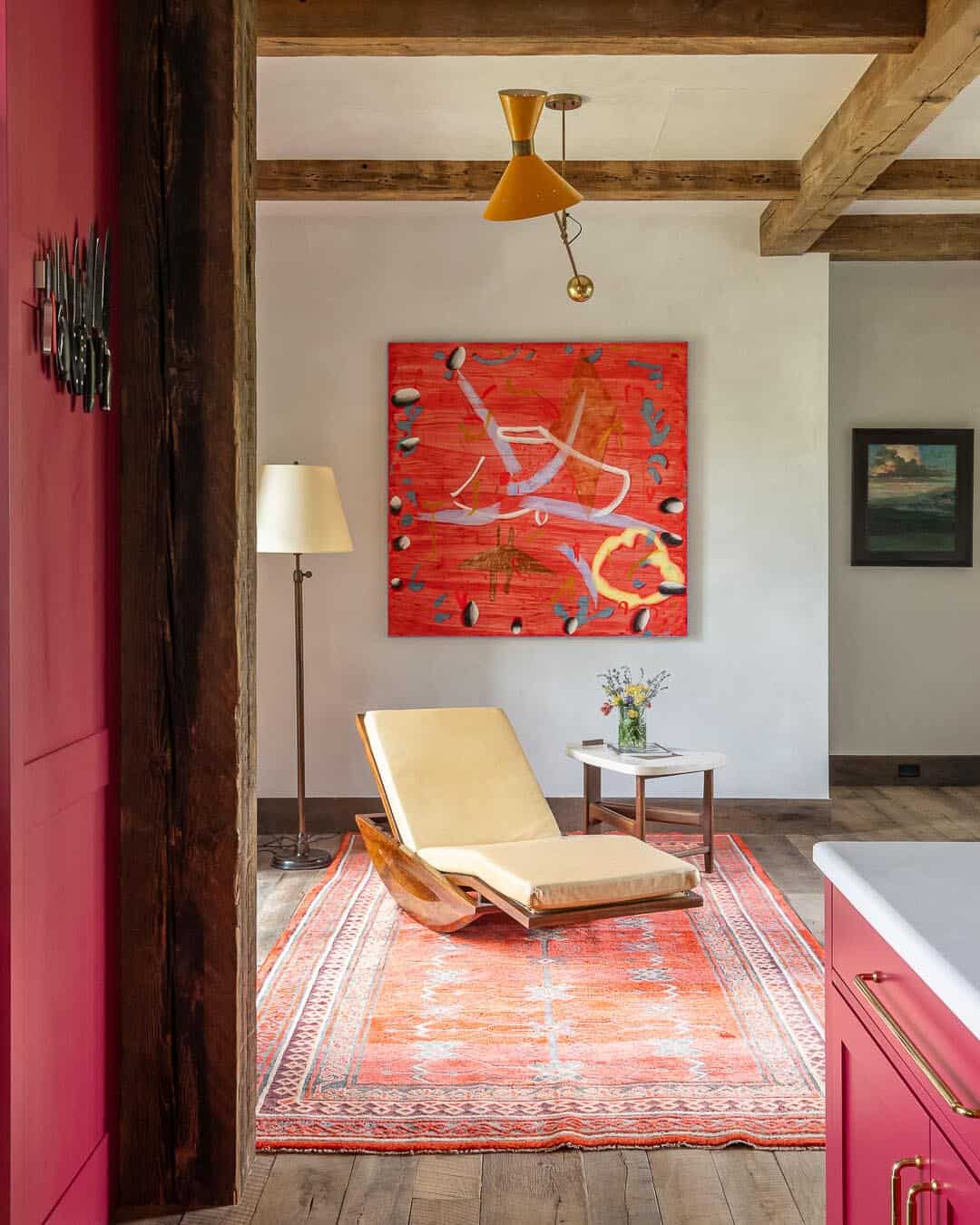 Sitting nook off kitchen with abstract red artwork, chaise lounge, and vintage rug