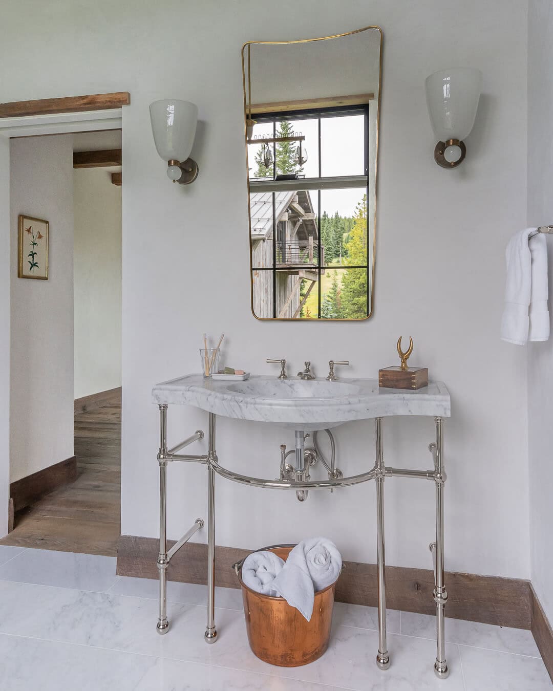 Primary bath with marble console sink, nickel fixtures, brass mirror, and mountain view