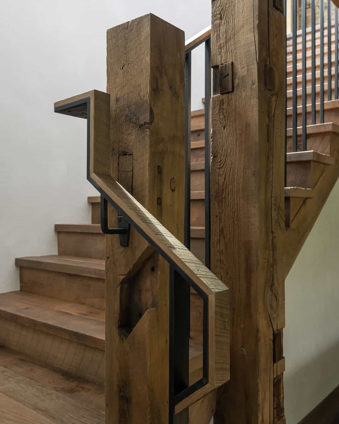 Reclaimed wood staircase with black steel railing detail in mountain home