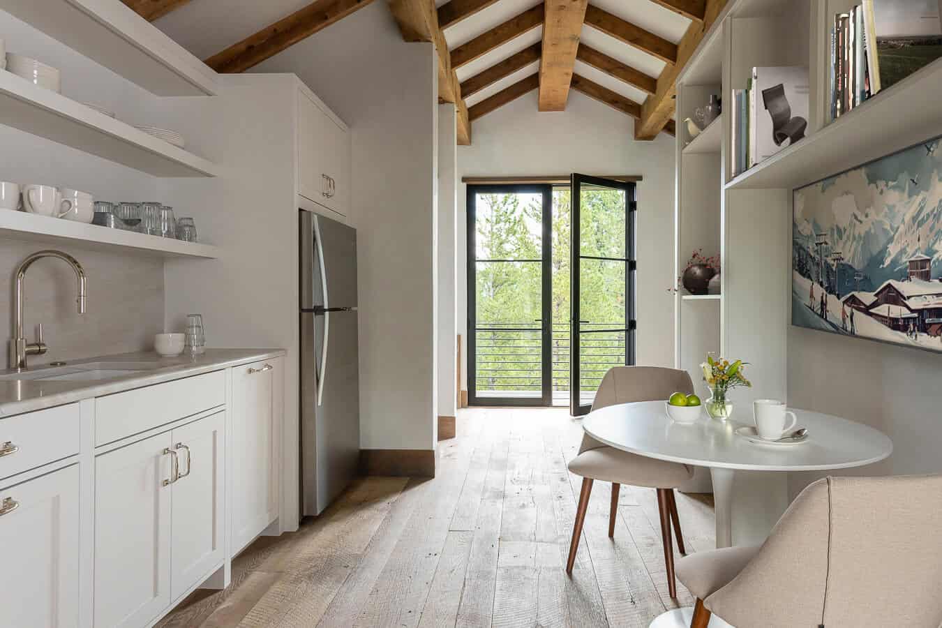 Guest cottage kitchenette with white cabinets, open shelving, and breakfast nook