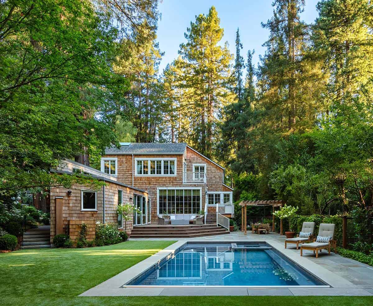 Cedar shingle home with rectangular pool, wood deck, and lounge chairs surrounded by redwood trees