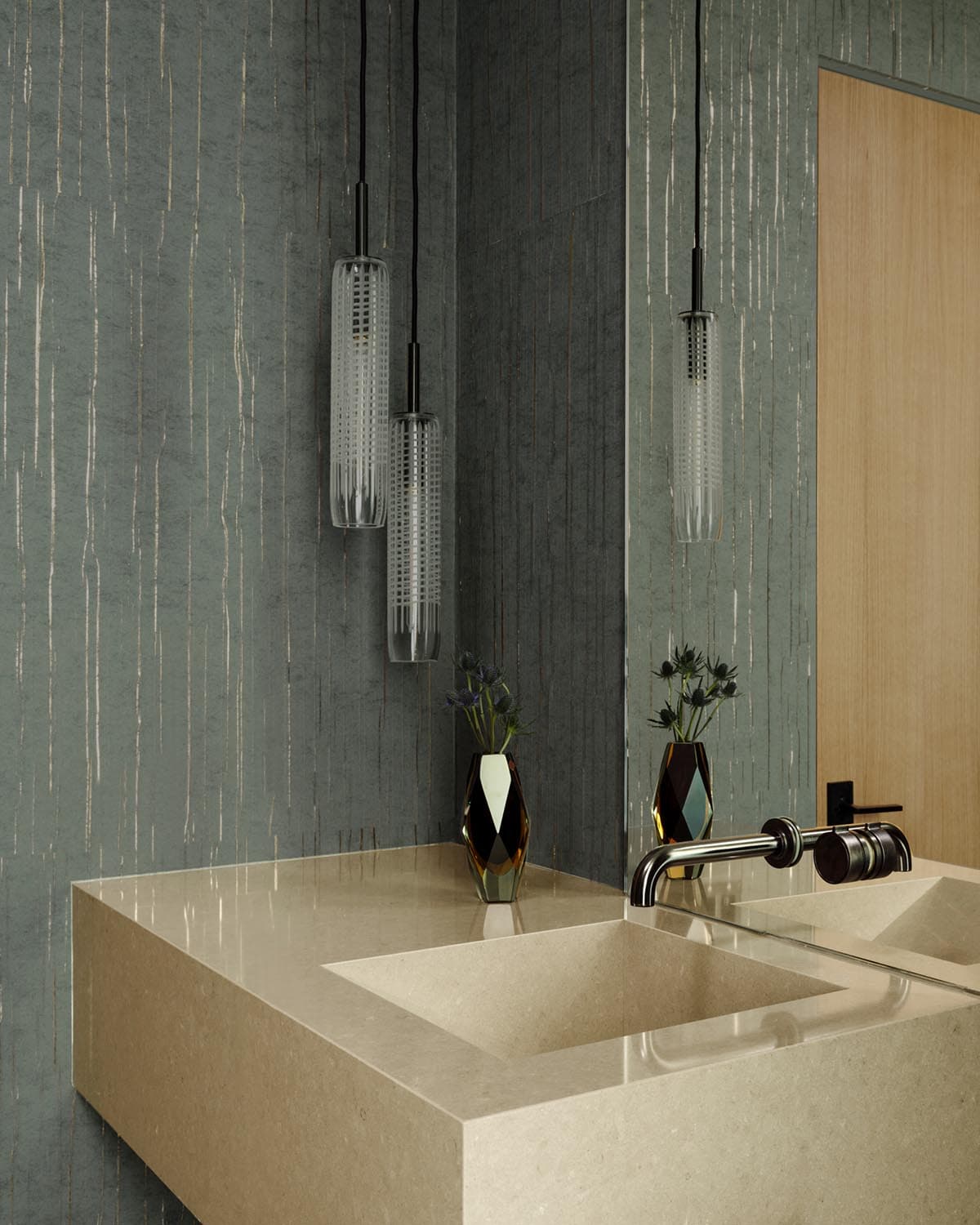Powder room with teal stone wall, carved stone vessel sink, wall-mount faucet, and cylindrical glass pendant lights