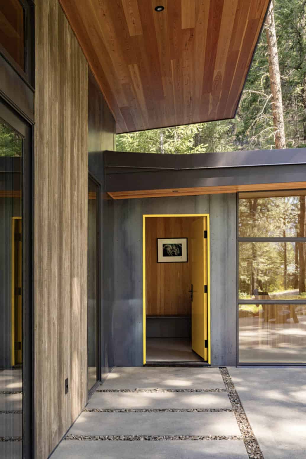 Yellow front door with steel-clad entry, wood ceiling overhang