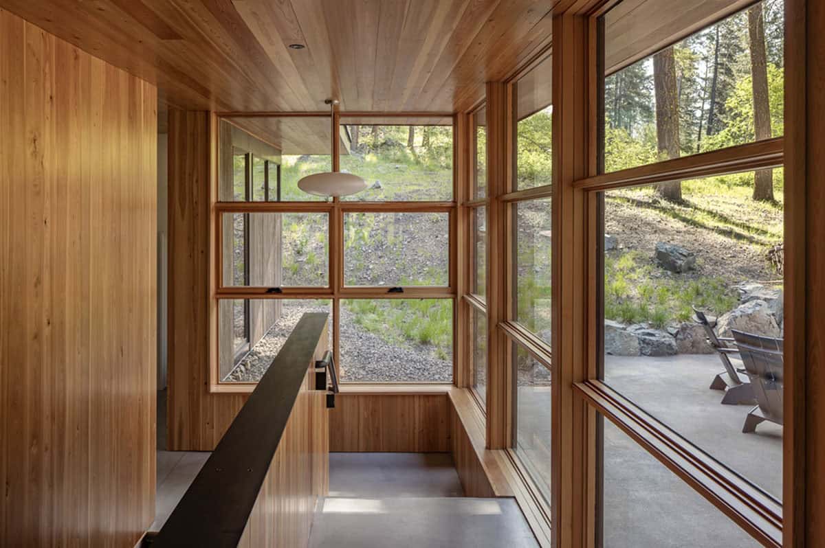 Douglas fir-lined entry with staircase and grid windows overlooking hillside