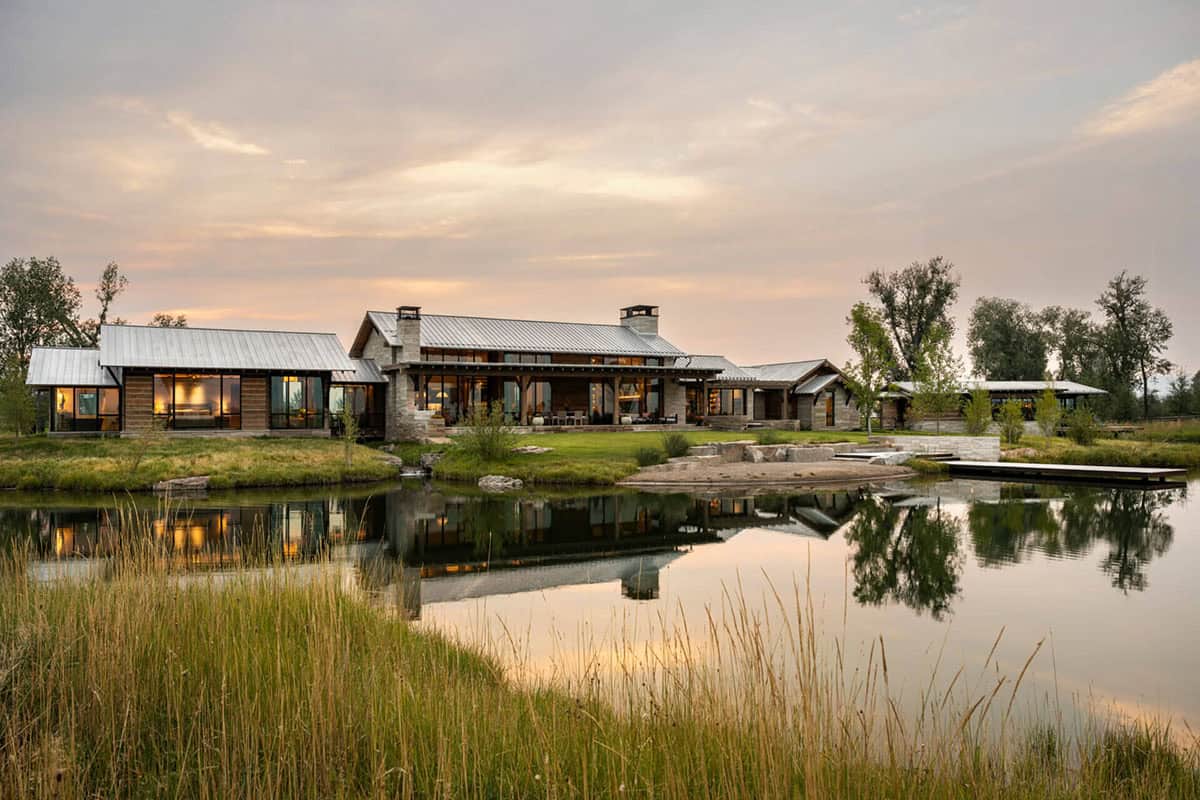 Modern ranch house reflected in a still pond at dusk, Montana
