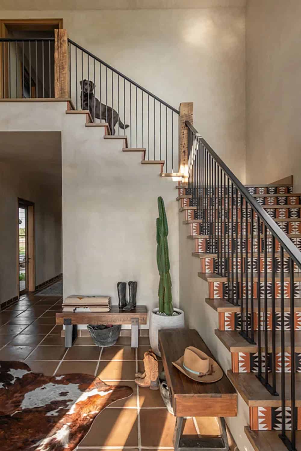 Staircase with patterned tile risers, wood bench, and dog sitting on steps