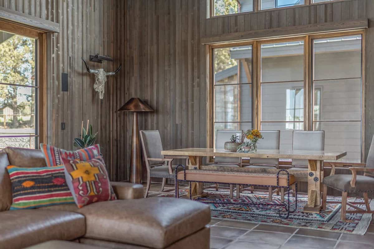Living room with wood-paneled walls, leather sofa, and skull mounted above dining table