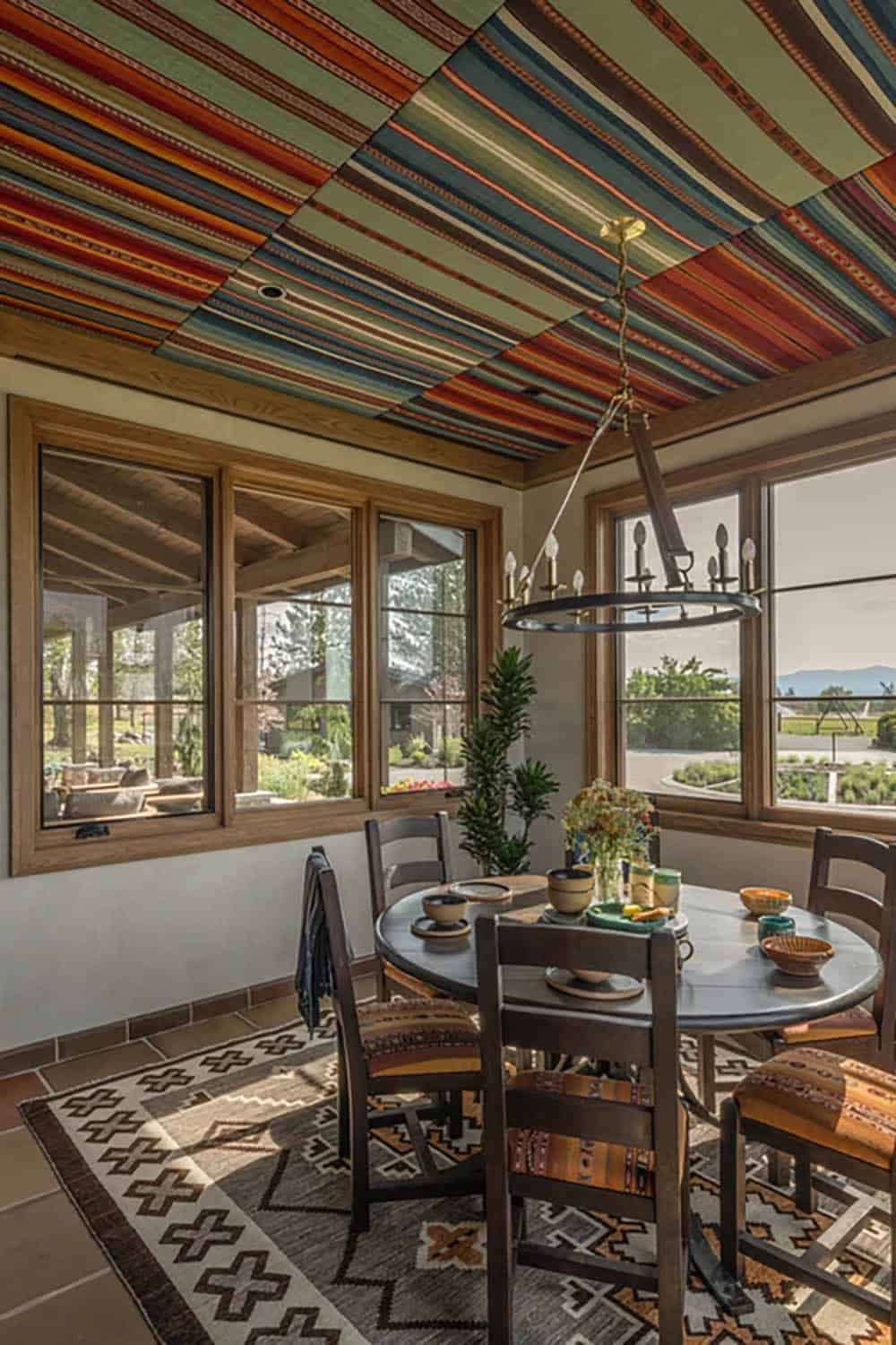 Breakfast nook with colorful striped ceiling and round table on patterned rug