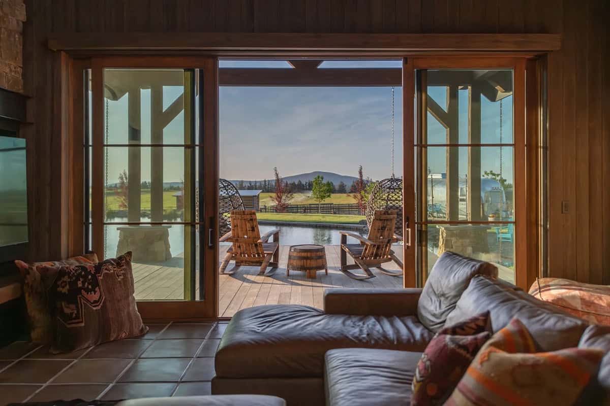 Living room view through sliding glass doors to deck and pond