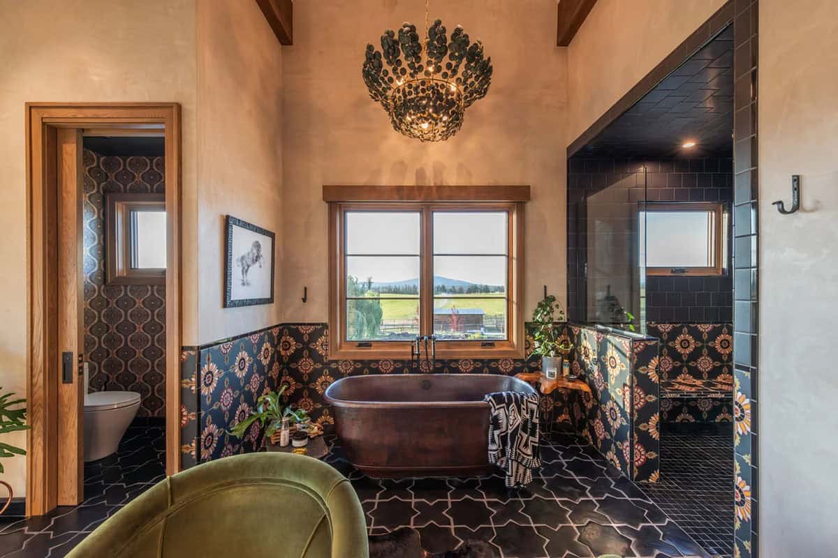 Bathroom with copper tub, ornate chandelier, and black patterned tile floor