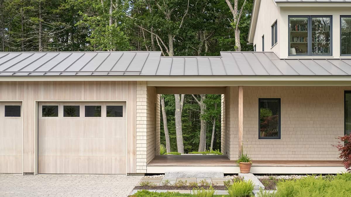 Entry porch and garage facade with cedar siding, pass-through breezeway, and natural stone path