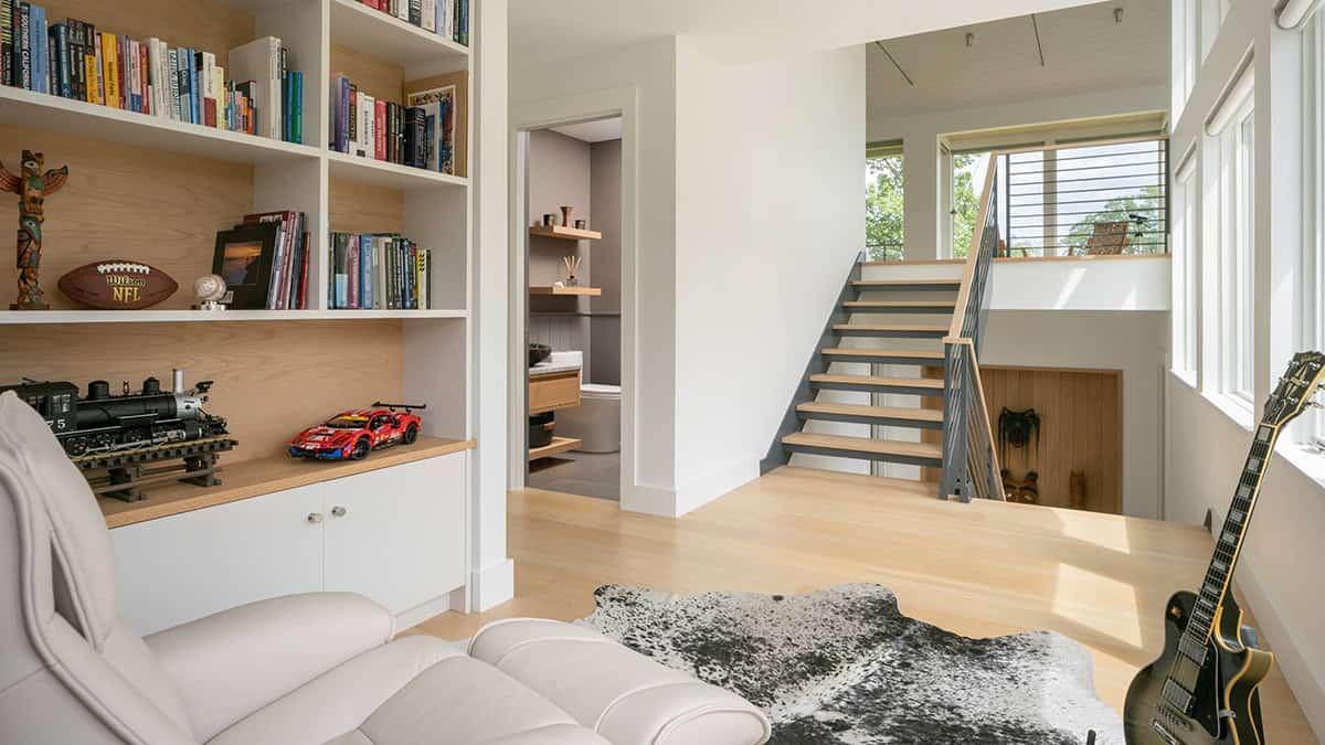 Home office and hallway with built-in bookshelves, open-riser staircase, and oak treads