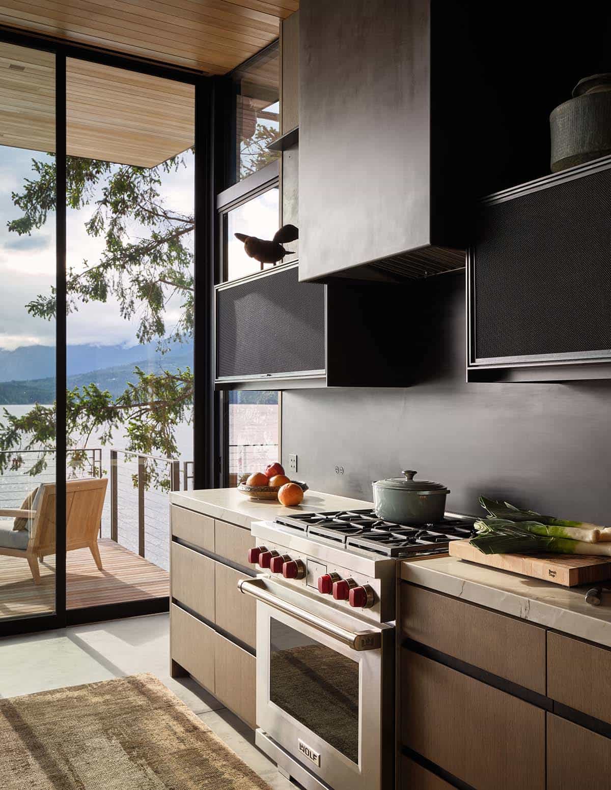 Professional Wolf range in a kitchen with lake and mountain views through sliding glass doors