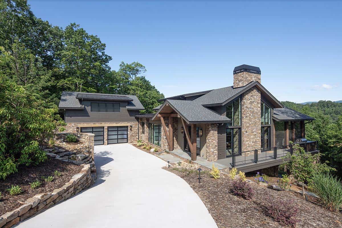Front view of mountain contemporary home surrounded by lush summer trees with two-car garage