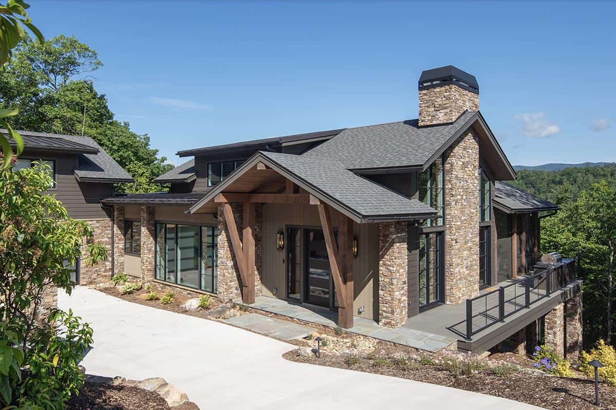 Close-up of home's timber frame entry porch with stone pillars and covered deck