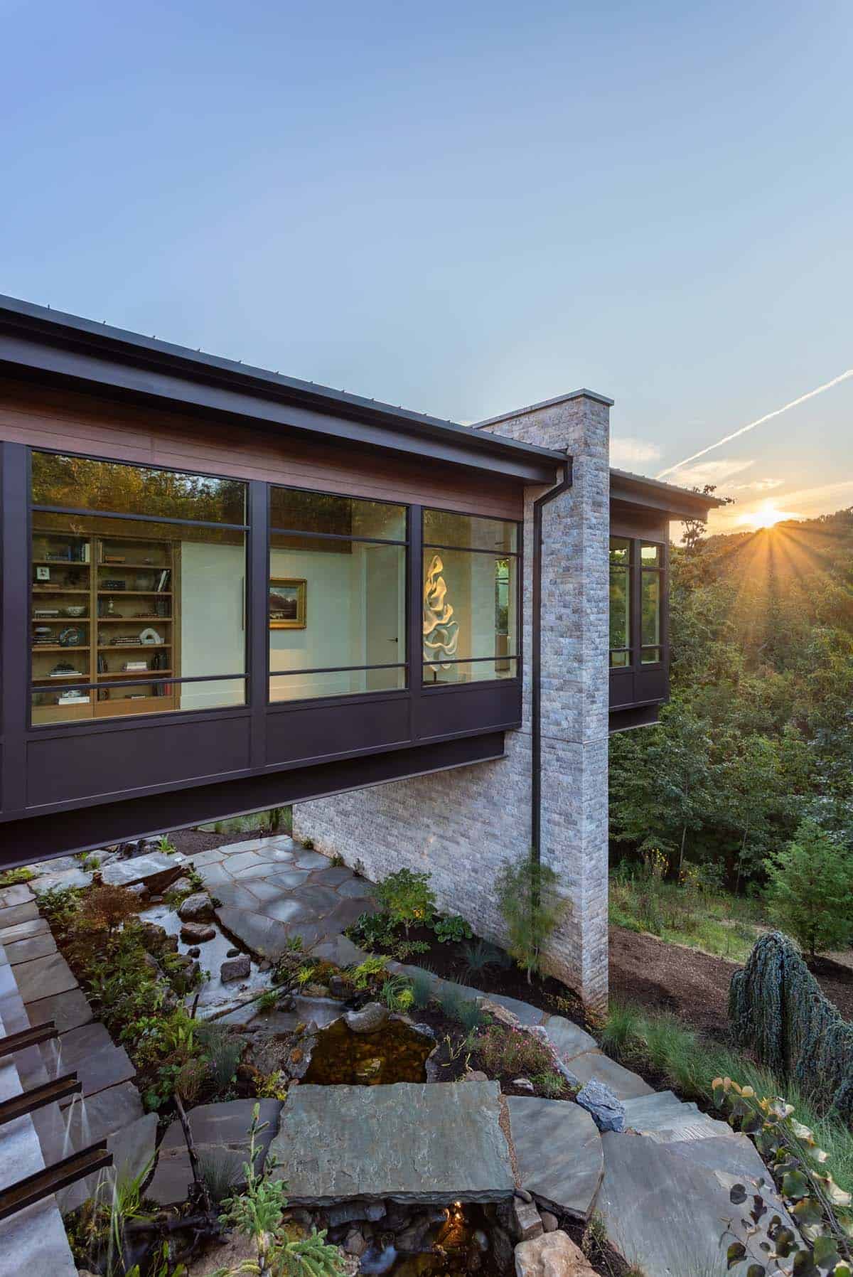 Sunset view of cantilevered library wing above terraced rock garden