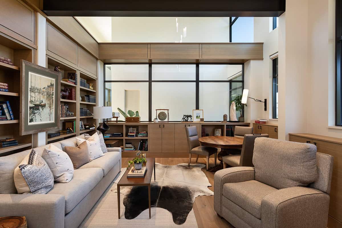 Study with built-in bookshelves, frosted glass partition, and casual seating area