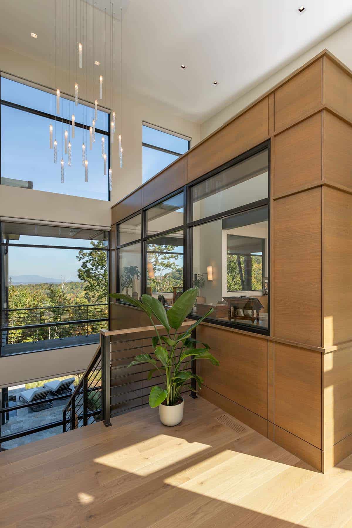 Upper landing with glass-enclosed study, pendant chandelier, and mountain views