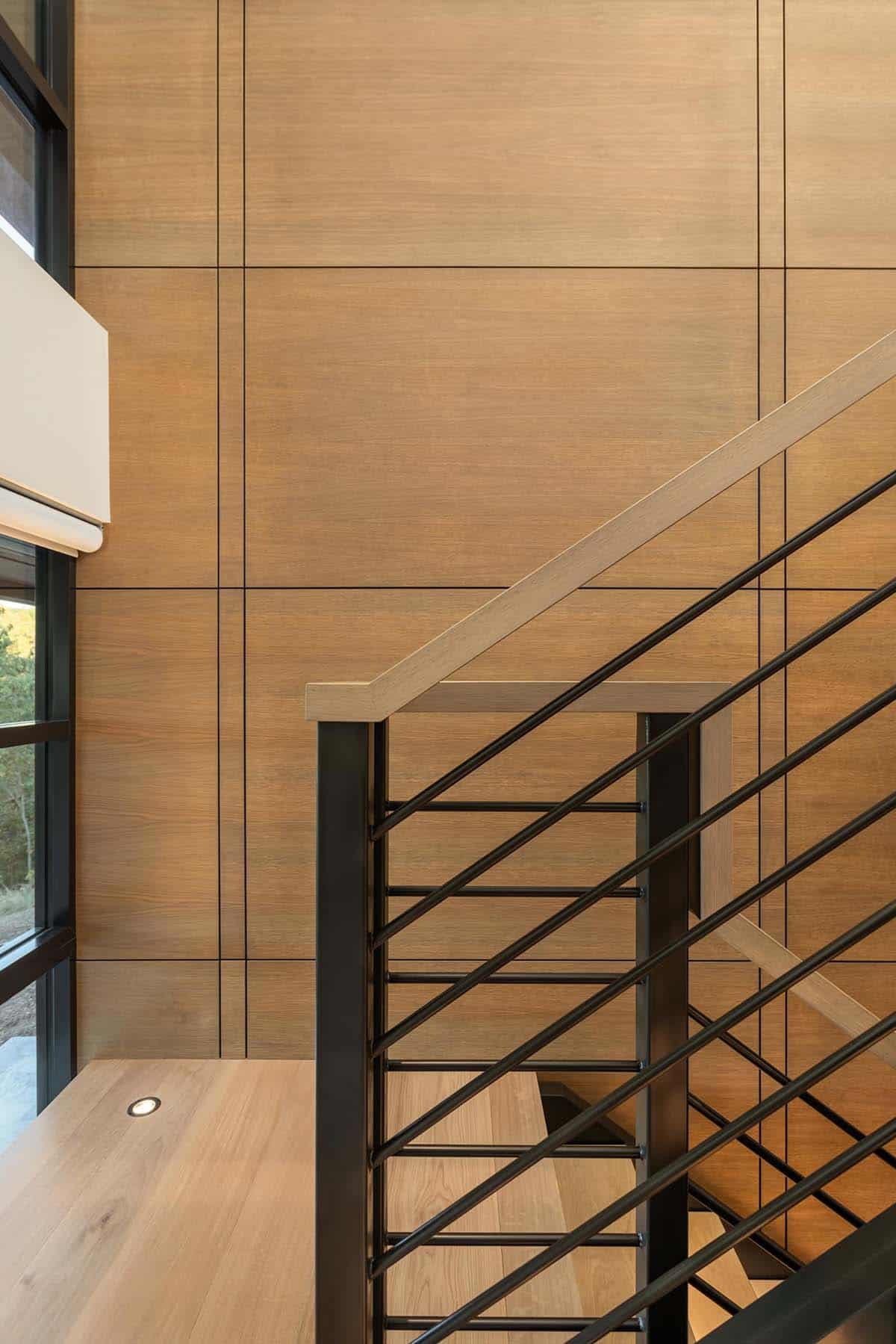 Oak wood panel staircase wall with black steel horizontal railing detail