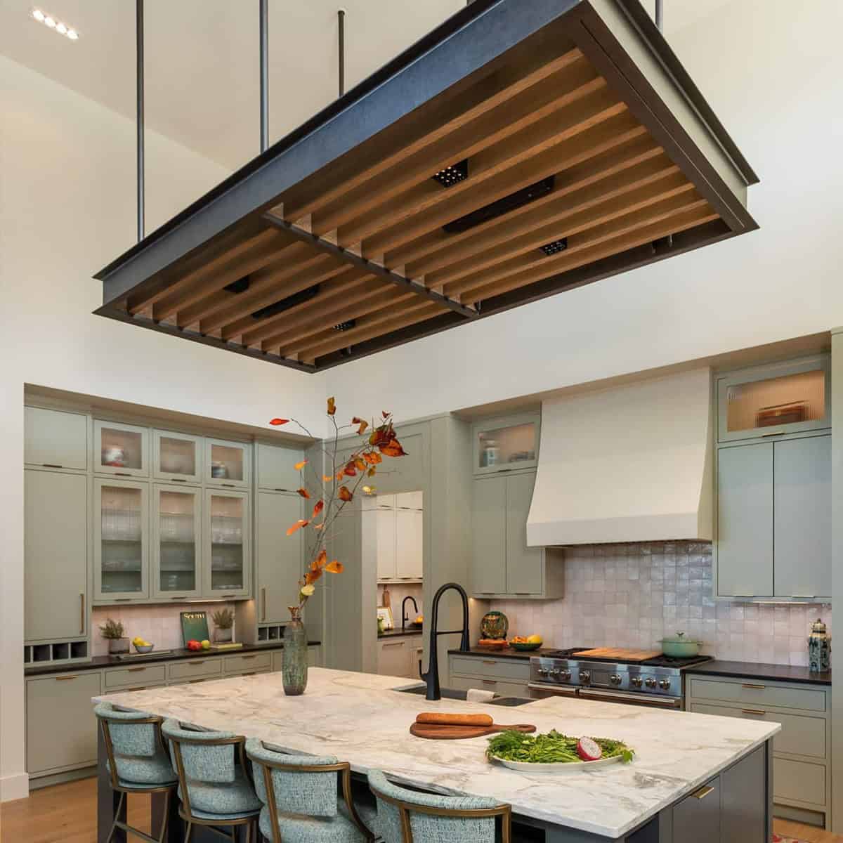 Kitchen overview with suspended wood slat ceiling feature above marble island