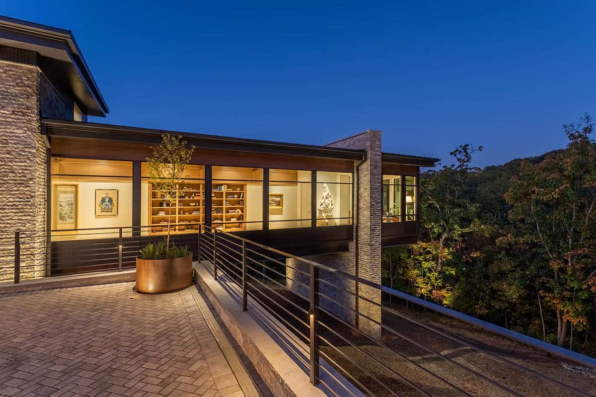 Nighttime view of lit interior library and study through floor-to-ceiling glass facade