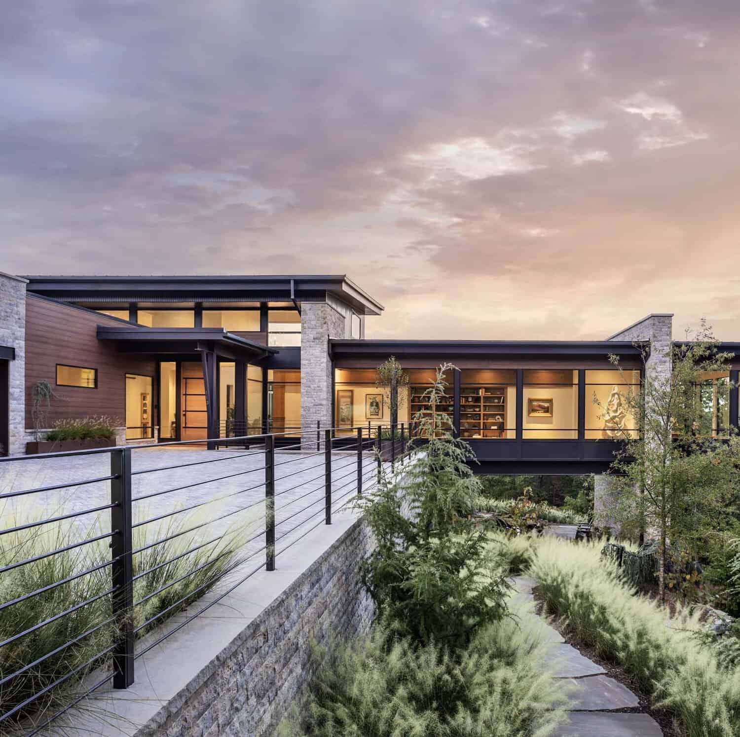 Mountain modern home front elevation at sunset with ornamental grasses and stone retaining wall