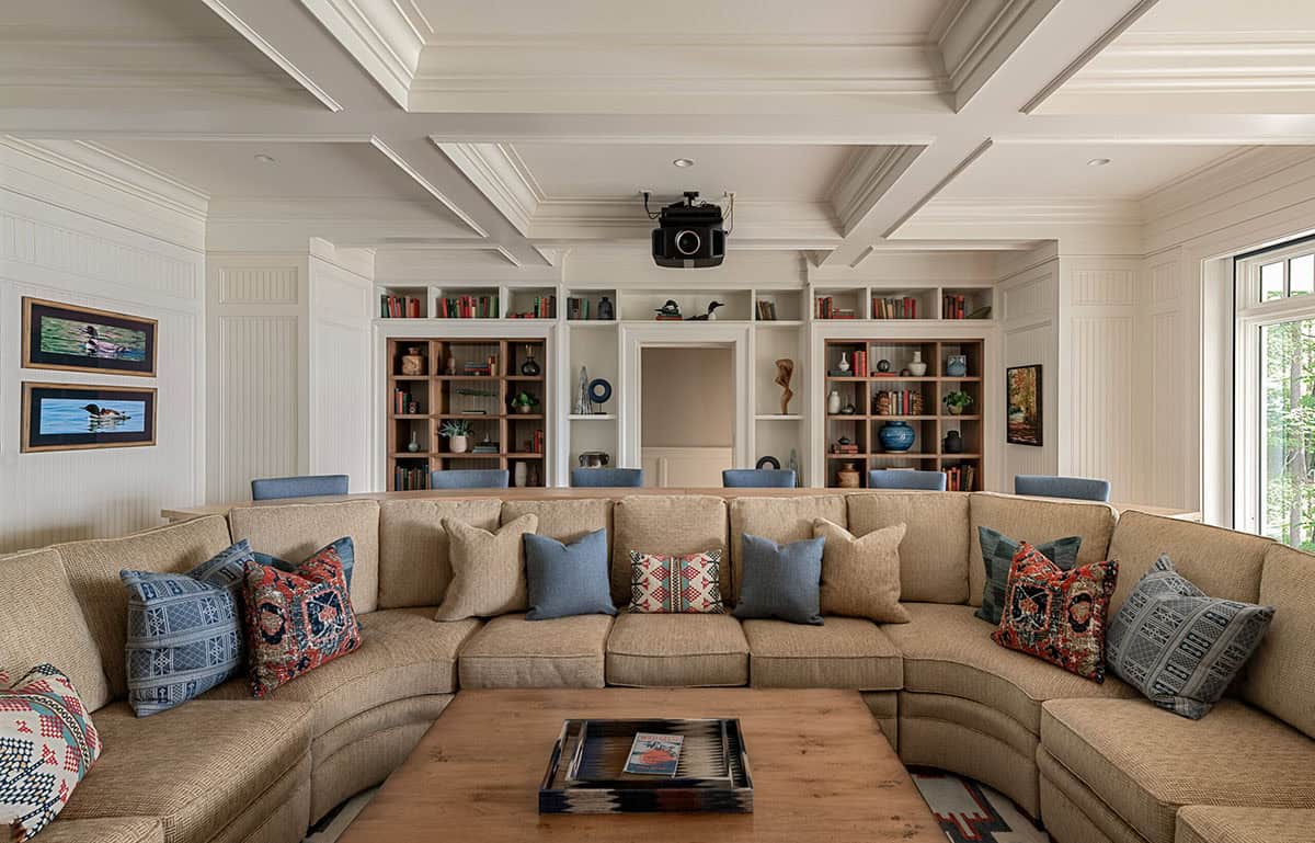 Media room with built-in bookshelves, sectional sofa, and ceiling-mounted projector