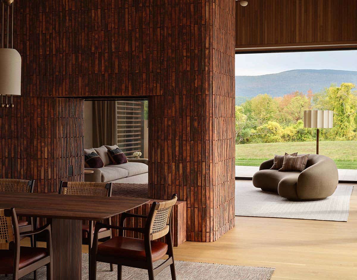 Interior dining area with cork-tile fireplace wall and mountain views through floor-to-ceiling glass