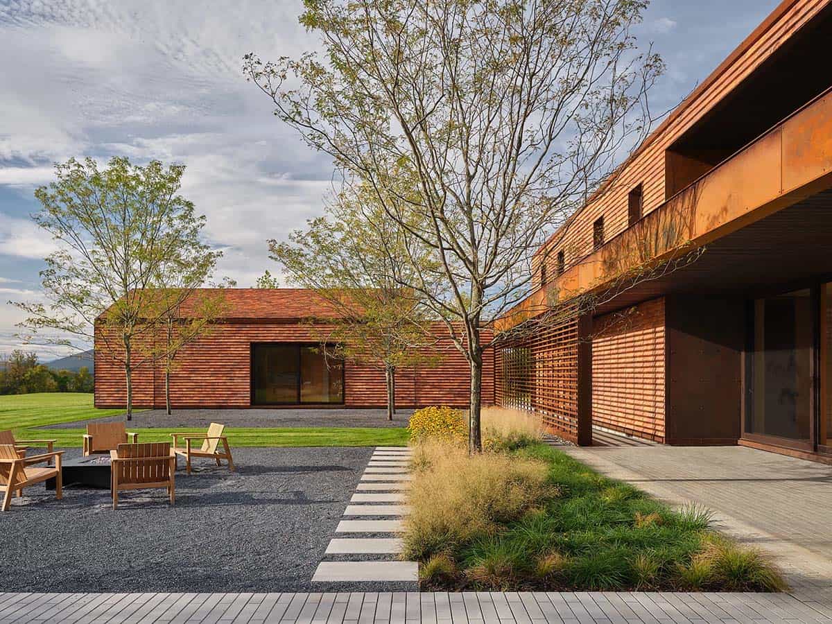 Inner courtyard with gravel fire pit area, ornamental trees, and cedar-clad guest structure