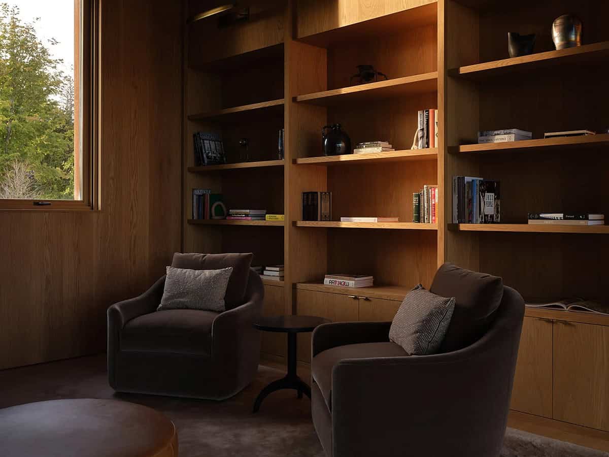 Cozy library nook with velvet armchairs and built-in oak bookshelves