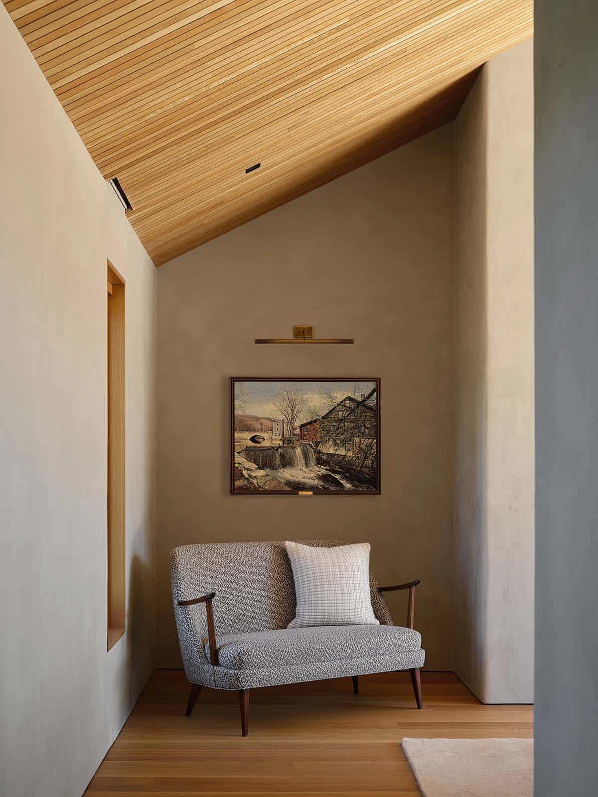 Bedroom sitting nook with mid-century loveseat, oil painting, and angled cedar ceiling