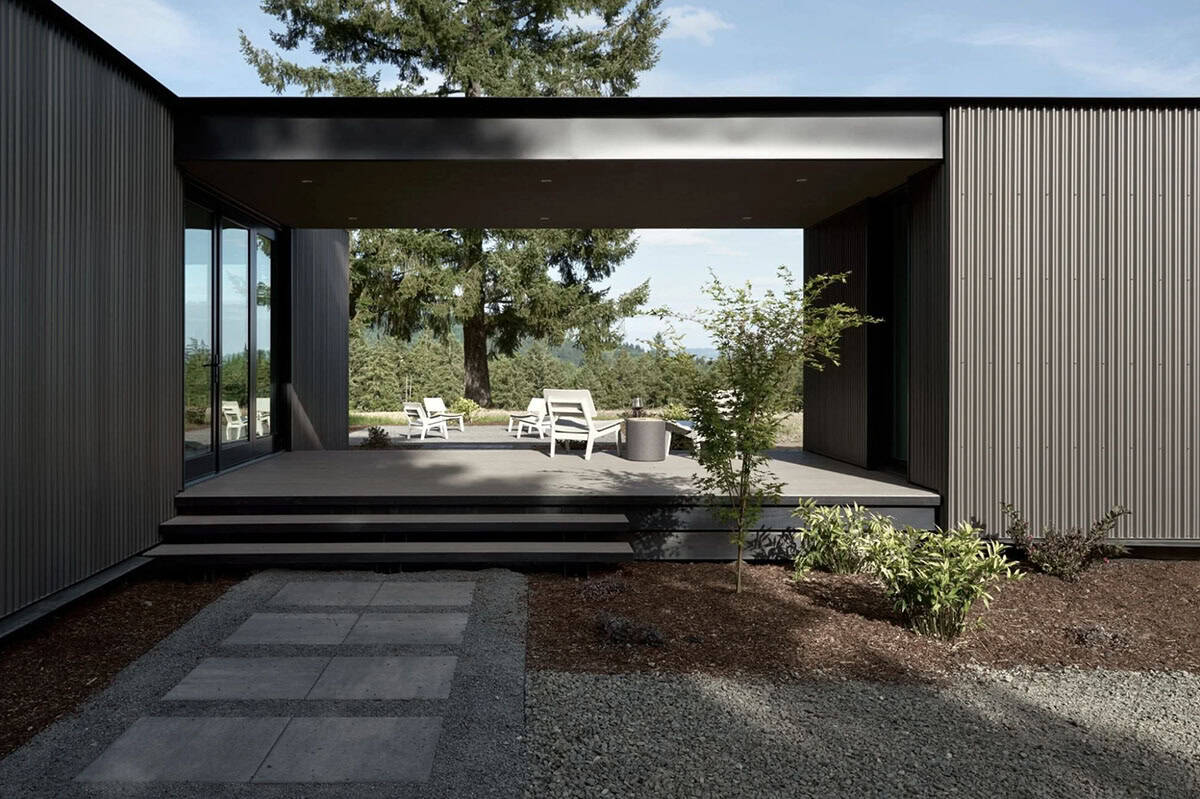 Covered patio breezeway framing a forest view with lounge chairs