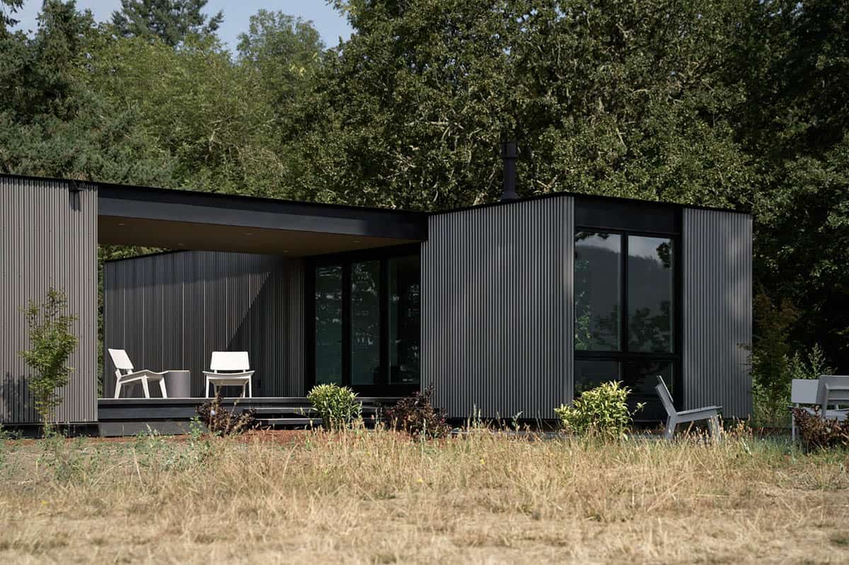 Corrugated metal home exterior with covered deck and chimney