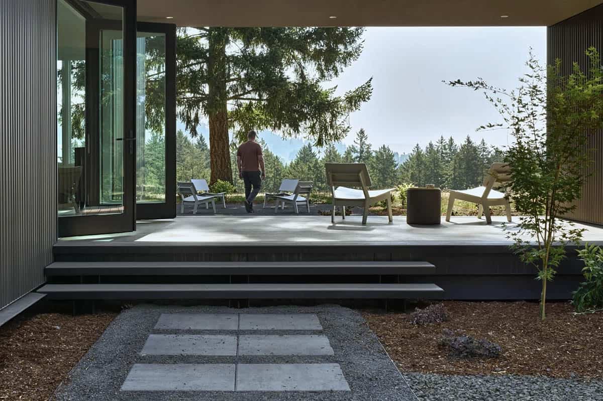 Person walking onto a stone patio beneath a covered breezeway