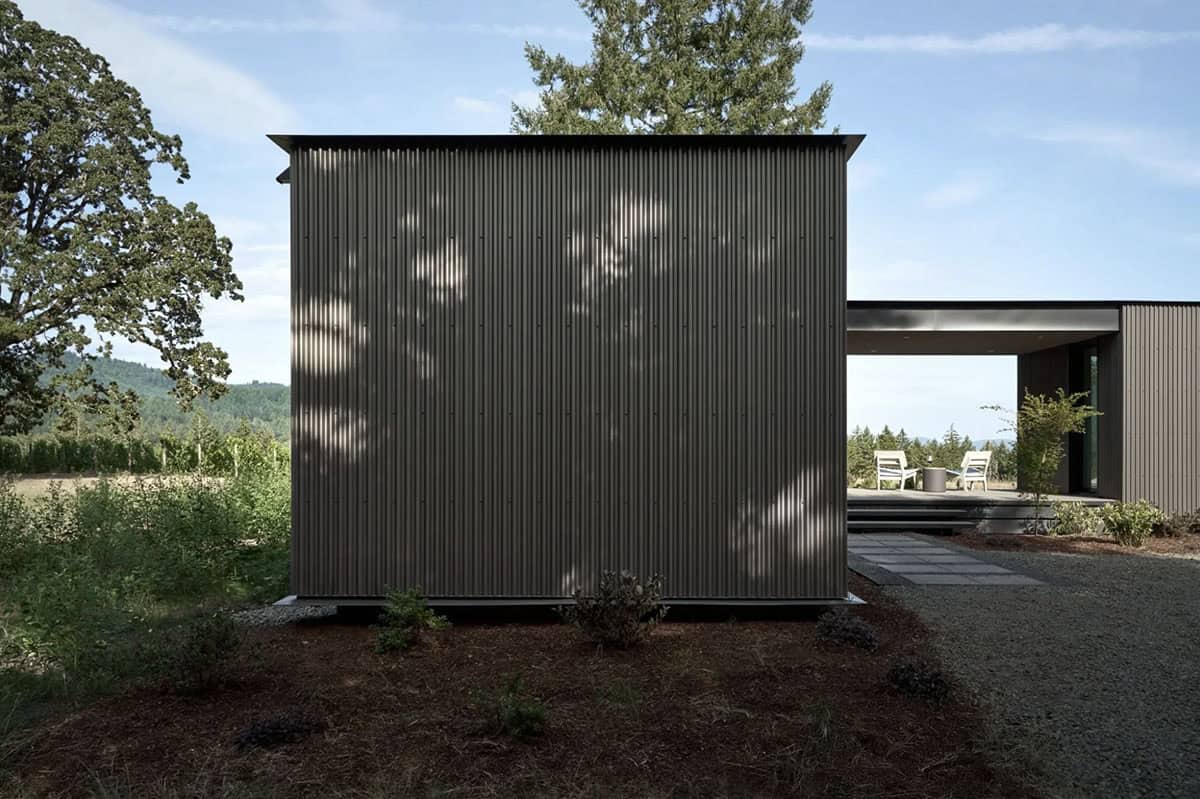  Close-up of corrugated metal siding with dappled tree shadows