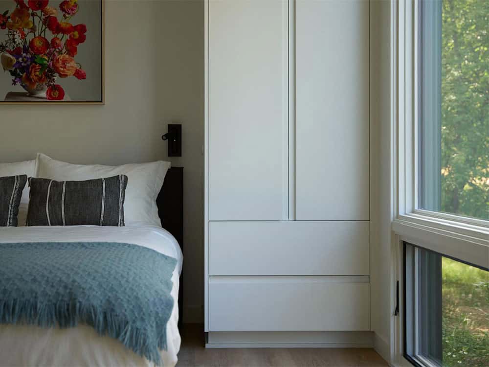 Bedroom nightstand detail with floral art and built-in wardrobe