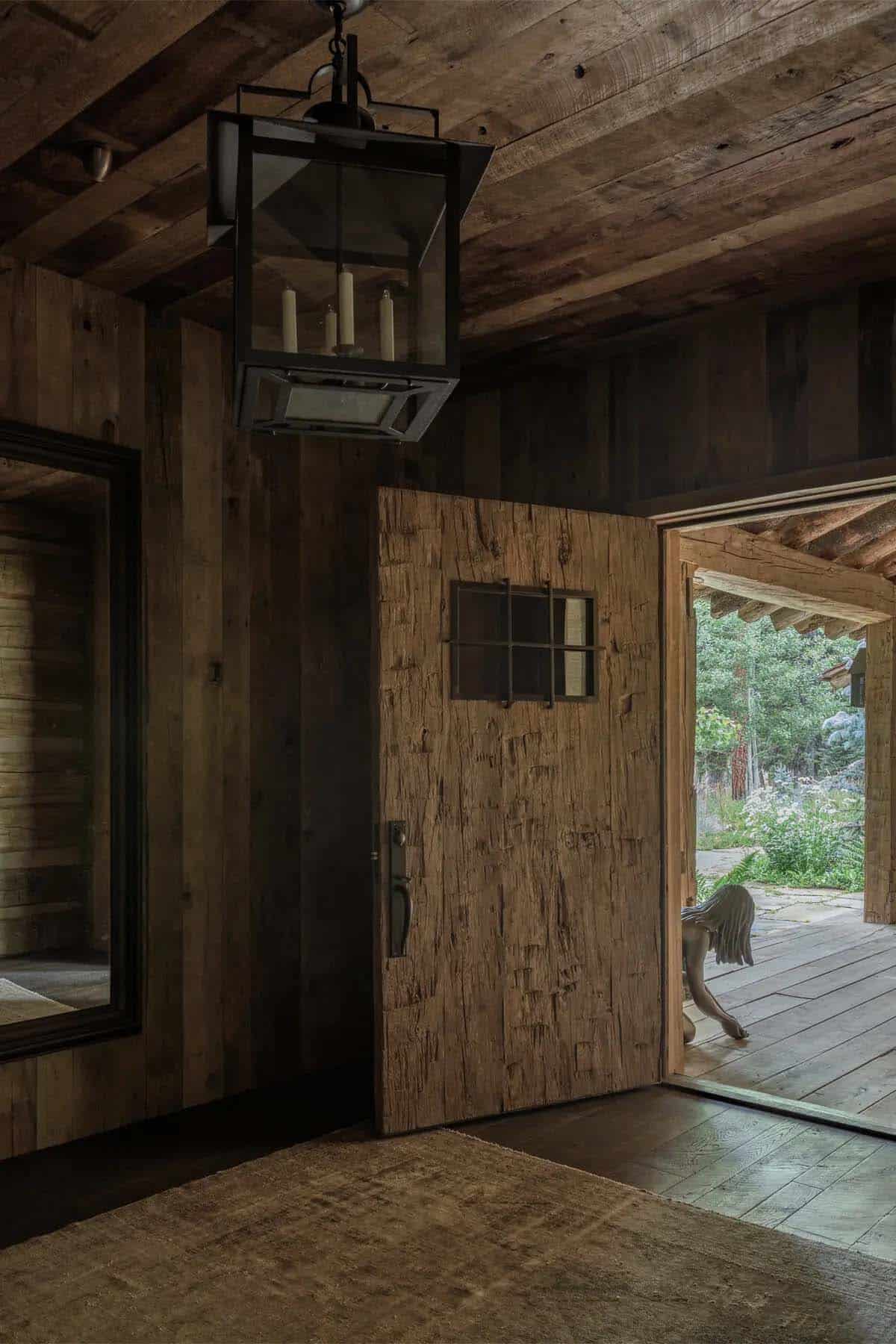 Rustic wood entryway with hewn plank door and hanging lantern