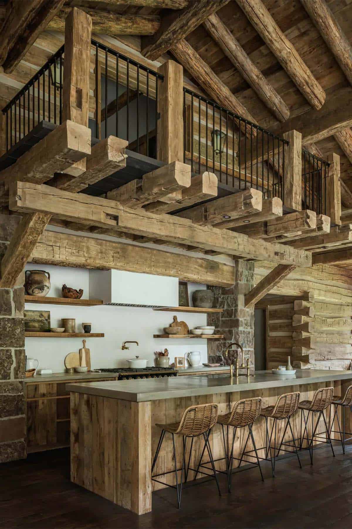 Log cabin kitchen with open shelving, concrete island, and loft railing above