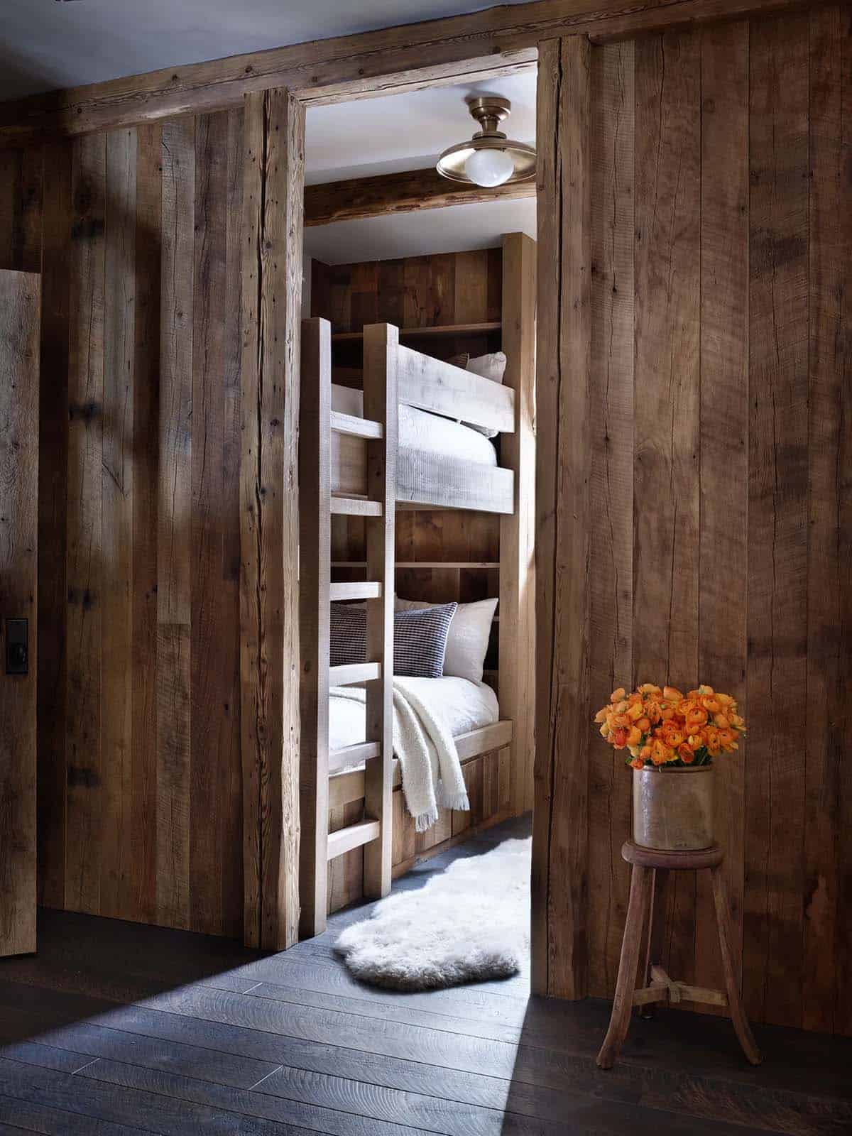Built-in bunk beds in wood-paneled nook with sheepskin rug