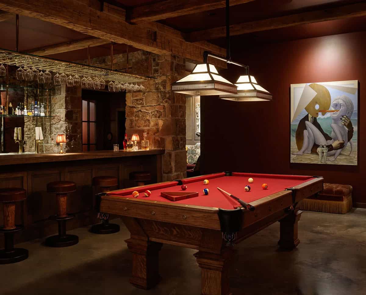 Rustic game room with pool table, stone bar, and surreal painting